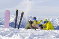 Three happy friends snowboarders and skier are having lunchtime on ski slope in sunny day in the mountains Royalty Free Stock Photo