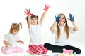 Three happy girls playing with finger colours