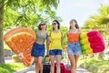 Three happy girls walking with inflatable mattresses at the beach outdoors in summer celebrating vacation. friends having fun on Royalty Free Stock Photo