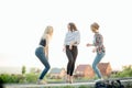 Three happy joyful young women jumping and laughing together at park Royalty Free Stock Photo