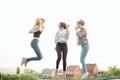 Three happy joyful young women jumping and laughing together at park Royalty Free Stock Photo