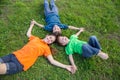 Three happy kids lying down on green grass Royalty Free Stock Photo