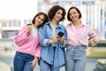 Three Happy Ladies With Smartphone And Takeaway Coffee Posing At Terrace Outdoors Royalty Free Stock Photo