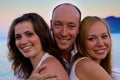 Three happy people on the beach sunset Royalty Free Stock Photo