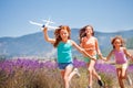 Happy girls running and playing with toy plane Royalty Free Stock Photo