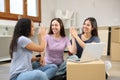 Three happy roommates moving home celebrating giving five Royalty Free Stock Photo