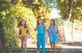 Three happy school girls running and holding hands in nature Royalty Free Stock Photo