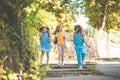 Three happy school girls running and holding hands in nature Royalty Free Stock Photo