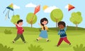 Three happy smiling diverse little children are playing with kites outdoors in a park Royalty Free Stock Photo