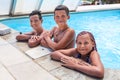 Three happy and smiling kids looking at camera while standing in watering hole Royalty Free Stock Photo