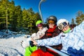 Three happy snowboarders sitting in elevator