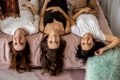 Three happy woman smiling lying on bed upside down relaxing together at home party Royalty Free Stock Photo