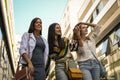 Three happy women walking city streets. Royalty Free Stock Photo