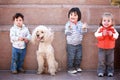 Three happy young children with pet dog.