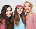 Three happy young women wearing colorful sweaters standing isolated over grey background Royalty Free Stock Photo