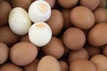 Three hard-boiled eggs, unwrapped. Placed on a background of brown unshelled hard-boiled eggs