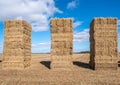 Three hay bale towers in a field