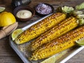 Three heads of yellow corn grilled lemon lime spicy, white sauce, rustic style Royalty Free Stock Photo