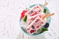 Three healthy berry and yogurt frozen iced lollies