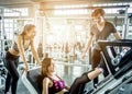 Three healthy friends working out in fitness gym together with fun and hapiness