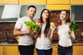 Three healthy, thin beautiful people hold in their hands and promote healthy food, vegetables and fruits.