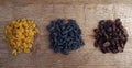 Three heaps of raisins of various varieties on a rough wooden