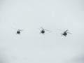 Three helicopters flying against a cloudy sky. Airshow demonstration Royalty Free Stock Photo