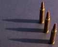 Three hunting bullets casting their shadow on a black background