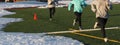 Three girls running on a turf field with snow on it Royalty Free Stock Photo