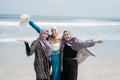 Three veiled women enjoy a holiday on the beach