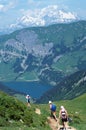 Three hikers in front of mont-blanc and saint guerin lake in Savoy, France