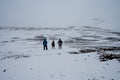 Three hikers on snow-covered trail to Askja Crater in northern Iceland.