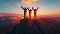 Three hikers triumphantly raise their arms atop mountain peak as sun sets behind them, casting warm glow over the majestic