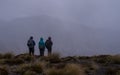 Three Hikers Watching Mountaintop Clouds