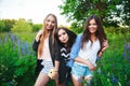 Three hipsters girls blonde and brunette taking self portrait on polaroid camera and smiling outdoor. Girls having fun together Royalty Free Stock Photo