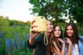 Three hipsters girls blonde and brunette taking self portrait on polaroid camera and smiling outdoor. Girls having fun together Royalty Free Stock Photo