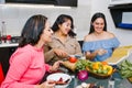 Three hispanic Female Friends cooking vegetables in a mexican Kitchen Together in Latin America Royalty Free Stock Photo