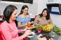 Three hispanic Female Friends cooking vegetables in a mexican Kitchen Together in Latin America Royalty Free Stock Photo