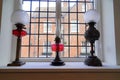 Three historic oil lamps on window sill