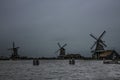 Three historic windmills on a cloudy day
