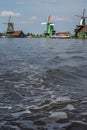 Three historical mills on the blue water in the day