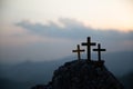 The three holy crosses of Jesus Christ shining through the red sky and clouds and bright rays background. Silhouette cross on Royalty Free Stock Photo