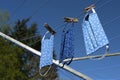 Three homemade community face masks from cotton cloth after washing drying on a clothesline against a blue sky, protection