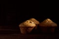 Three Homemade muffins cupcake lies on old book on black background Royalty Free Stock Photo