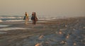 Three horseback riders travel along beach