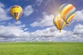 Three Hot Air Balloons, Sun-flare, Blue Sky Above Green Field Royalty Free Stock Photo