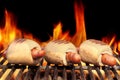 Three Hot Dogs On Flaming BBQ Grill Royalty Free Stock Photo