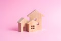 Three houses on a pink background. Buying and selling Royalty Free Stock Photo