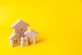 Three houses on a yellow background. Buying and selling of real estate, construction. Apartments and apartments. City, settlement. Royalty Free Stock Photo