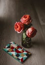 Three roses standing in a glass jar on a wooden floor  in daylight Royalty Free Stock Photo